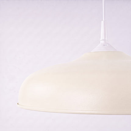 Suspension Pur Gina dôme en acier beige sur fond coloré, vue de trois quarts