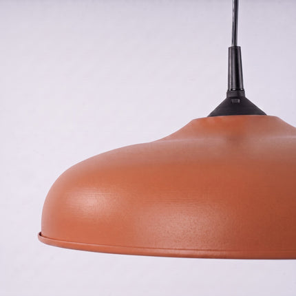 Suspension Pur Gina dôme en acier ocre rouge sur fond coloré, vue de trois quarts
