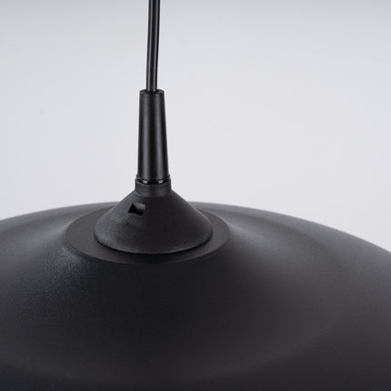 Suspension Pur Gina noir mat suspendue au-dessus d'une banquette avec coussins texture