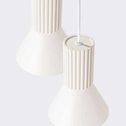 suspension ronde 3 cônes à fût cannelé beige, vue sur fond coloré