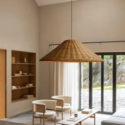 Suspension en rotin chapeau éclairant un salon à l'ambiance bohème