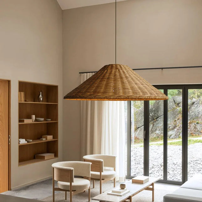 Suspension en rotin chapeau éclairant un salon à l'ambiance bohème