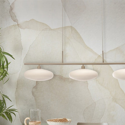 Suspension Sapporo 3 disques 115 cm au-dessus d'une table à manger, verre blanc et barre sable
