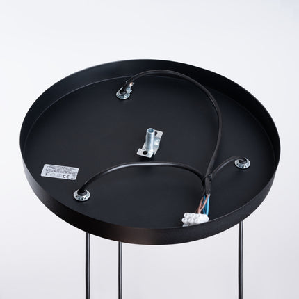 Gros plan sur l'anneau noir incliné de la suspension Saturne, détail de la finition acier mat.