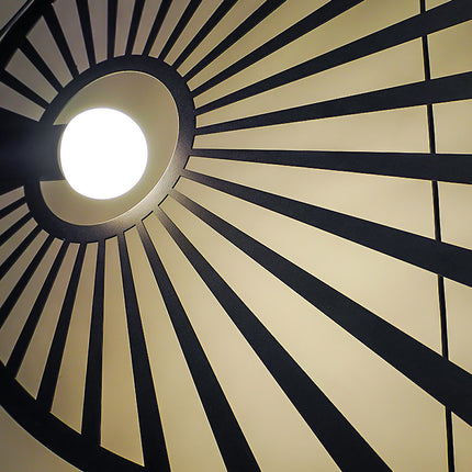 Vue de dessous du découpage rayonnant de la suspension Soleil Lumineux noire allumée