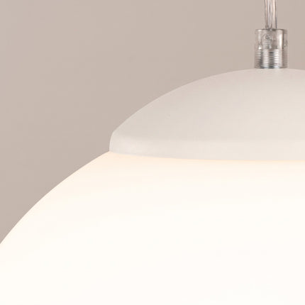 Suspension Sphère Opaline beige clair 20 cm sur fond coloré, vue de trois quarts