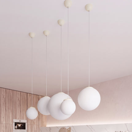 Suspension Sphère Opaline beige clair 20 cm au-dessus d'une table à manger
