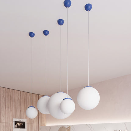 Suspension Sphère Opaline bleu outremer 20 cm au-dessus d'une table à manger
