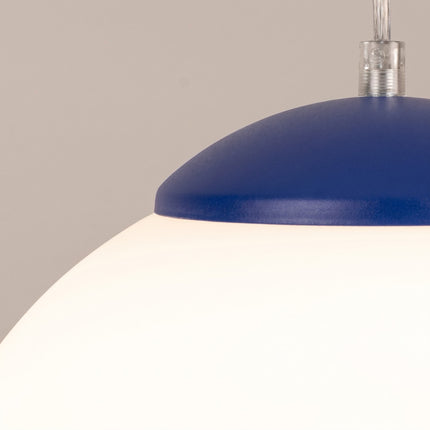 Suspension Sphère Opaline bleu outremer 30 cm sur fond coloré, vue de trois quarts