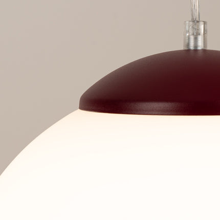 Suspension Sphère Opaline bordeaux 30 cm sur fond coloré, vue de trois quarts