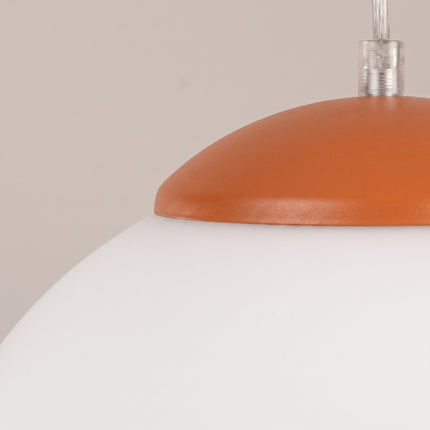 Suspension Sphère Opaline ocre rouge 20 cm sur fond coloré, vue de trois quarts