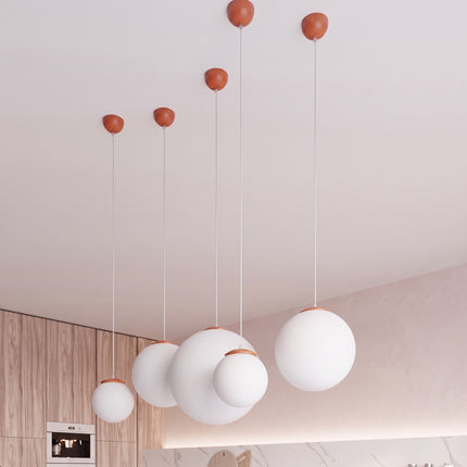 Suspension Sphère Opaline ocre rouge 40 cm au-dessus d'une table à manger