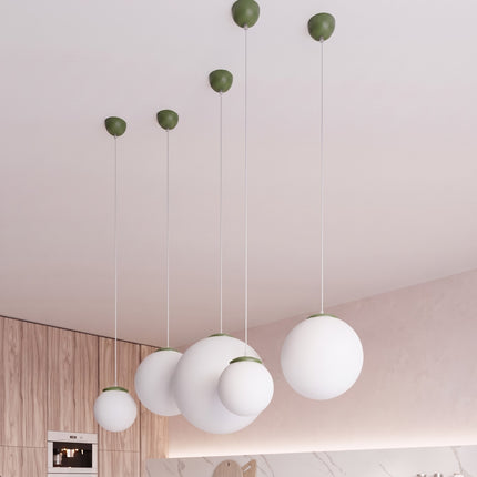 Suspension Sphère Opaline vert olive 30 cm au-dessus d'une table à manger