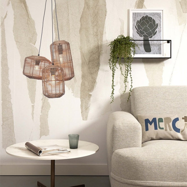 Three Tanami braided rattan lampshades hanging near an armchair and a wall shelf