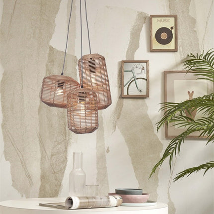 Suspension Tanami trois tubes en rotin tressé au-dessus d'une petite table ronde et de chaises