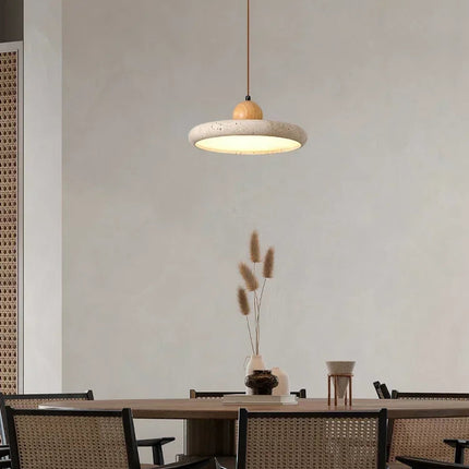 Suspension plate en travertin allumée au-dessus d'un coin repas convivial