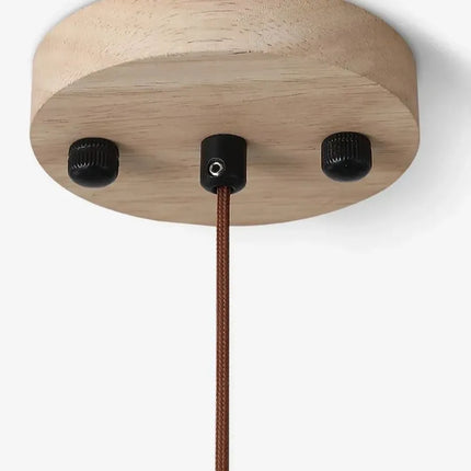 Détail de la rosace en bois clair avec câble textile brun et fixations de la suspension travertin