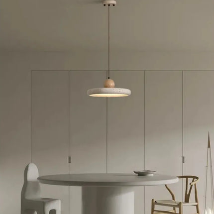 Suspension plate en travertin et bois suspendue au-dessus d'une table ronde décorée