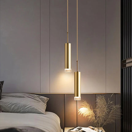 Suspension tube doré à 2 têtes allumée au-dessus d'un chevet dans une chambre contemporaine