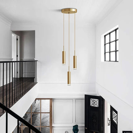 Suspension tube doré à 3 têtes dans une cage d'escalier lumineuse