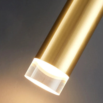 Gros plan sur le tube doré allumé diffusant une lumière chaude par son embout cristal