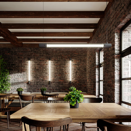 Suspension tube lumineux noir allumée au-dessus d'une table à manger dans un intérieur loft