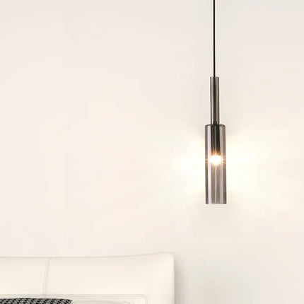 Suspension tube verre fumé et métal noir mat sur un mur clair, ambiance chambre minimaliste
