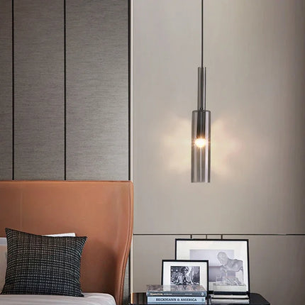 Suspension tube en verre fumé suspendue au-dessus d'une table de chevet, chambre épurée