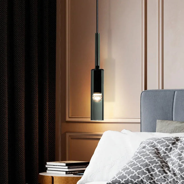 Suspension tube en verre fumé noir au-dessus d'un chevet dans une chambre feutrée