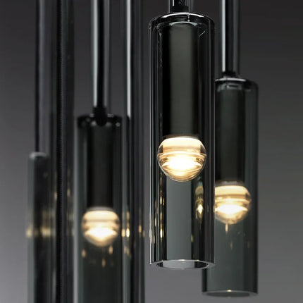 Gros plan sur plusieurs tubes en verre fumé noir et leurs ampoules globe allumées