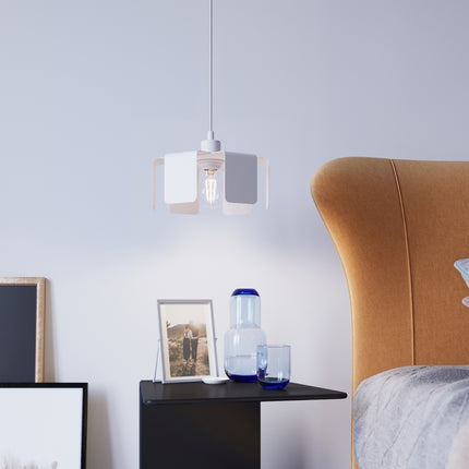 Suspension Tulipe blanche installée au-dessus d'une table de chevet dans une chambre lumineuse.