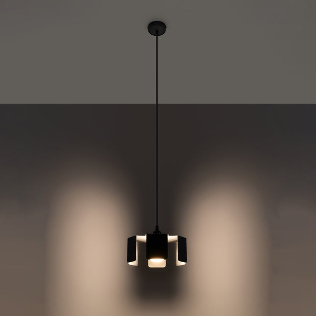 Suspension Tulipe noire allumée diffusant une lumière chaude entre ses pétales de métal.
