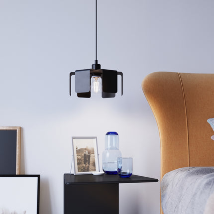 Suspension Tulipe noire installée au-dessus d'une table de chevet dans une chambre lumineuse.