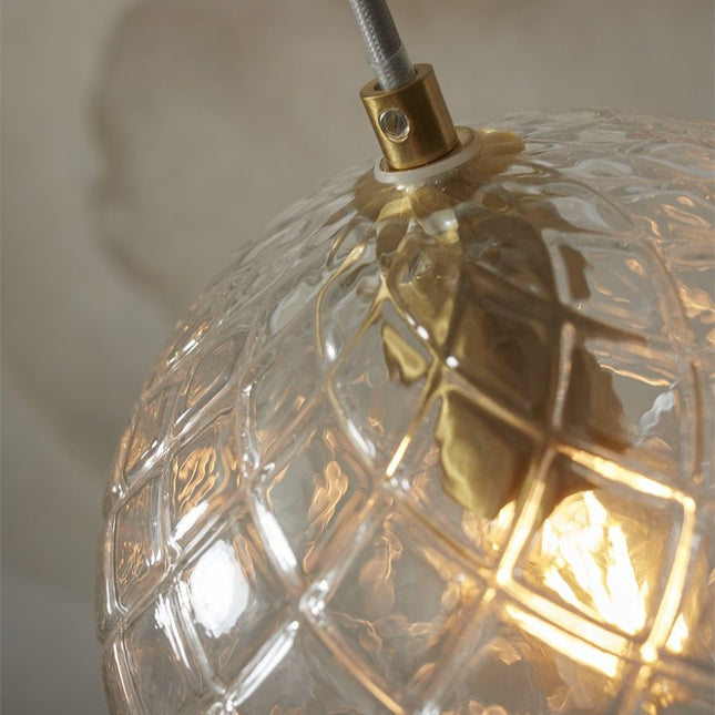 Detail of the golden fixing and the waffle glass globe of the Venice pendant light