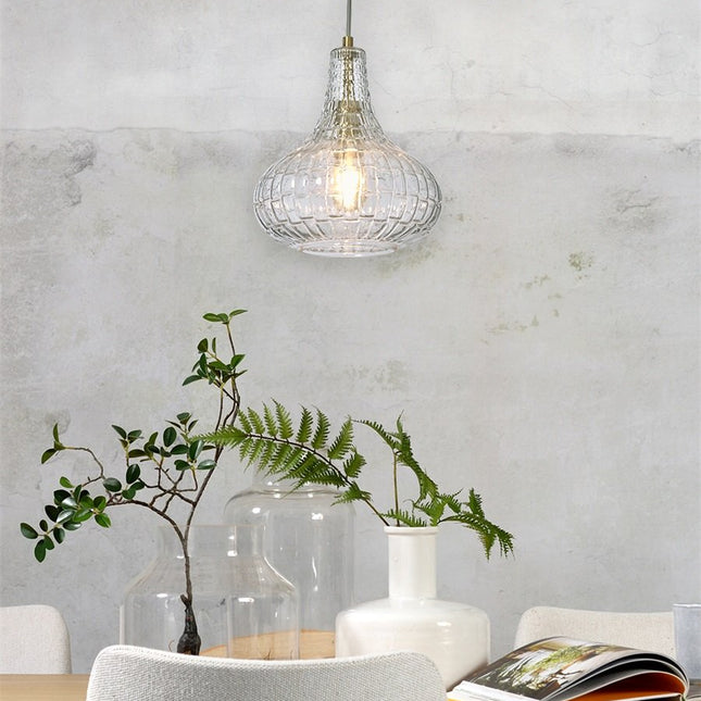 Suspension Venice en verre gaufré transparent et doré au-dessus d'une table à manger avec plantes
