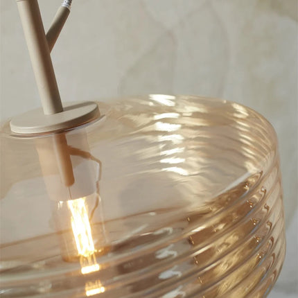 Détail du verre strié ambre de la suspension Verona et de la fixation ton sable
