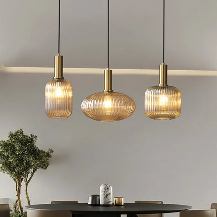 Suspension en verre côtelé ambré au-dessus d'un salon, lumière chaude et vintage.