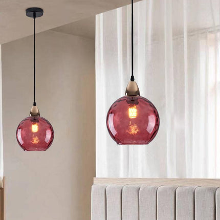 Deux suspensions à globe en verre martelé aux reflets prune près d'un voilage clair