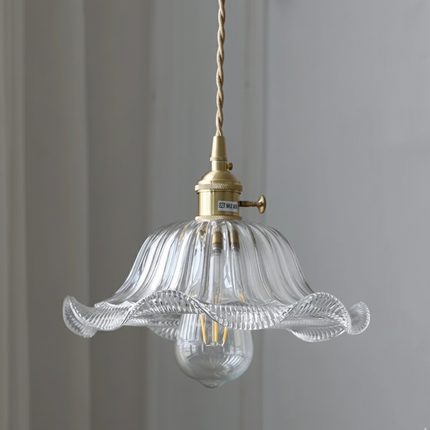 Suspension en verre ondulé transparent en forme de fleur et douille en laiton doré sur mur clair