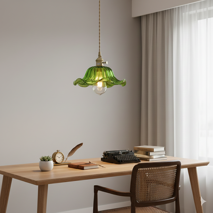Suspension en verre vert floral allumée au-dessus d'un bureau en bois avec fauteuil cannage japandi
