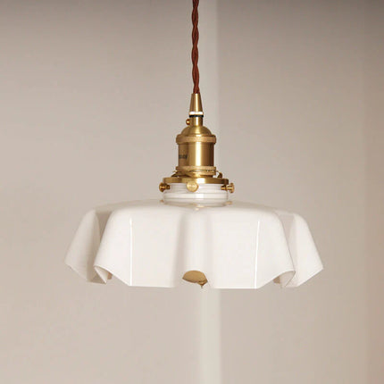 Détail de la monture en laiton poli et du câble textile brun de la suspension en verre opalin blanc