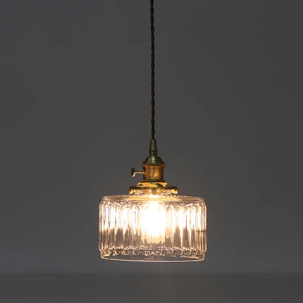 Suspension en verre strié allumée diffusant un halo lumineux tamisé sur fond sombre