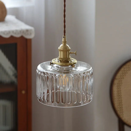 Suspension en verre strié allumée dans un intérieur vintage près d'un vaisselier en bois