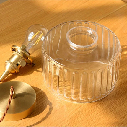 Globe en verre strié démonté à côté de la douille laiton, du socle et d'une ampoule E27