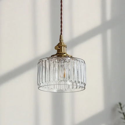 Suspension en verre strié transparent baignée par la lumière naturelle d'une fenetre