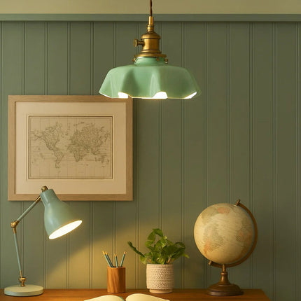 Suspension en verre vert allumée au-dessus d'un coin bureau aux murs verts et lampe assortie