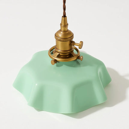 Détail de l'abat-jour en verre vert festonné et de la douille en laiton doré de la suspension