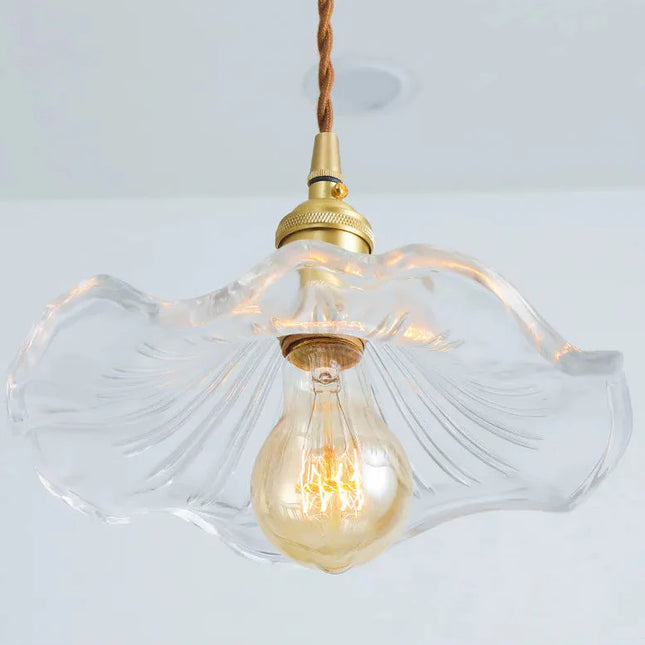 Détail de l'abat-jour en verre ondulé cannelé et de l'ampoule ambrée à culot E27