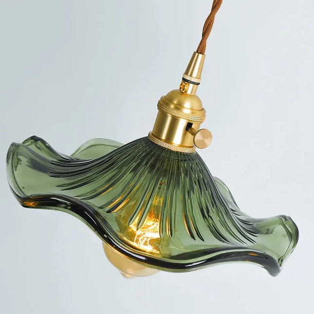 Abat-jour en verre vert ondulé et douille en laiton d'une suspension vintage vue de côté