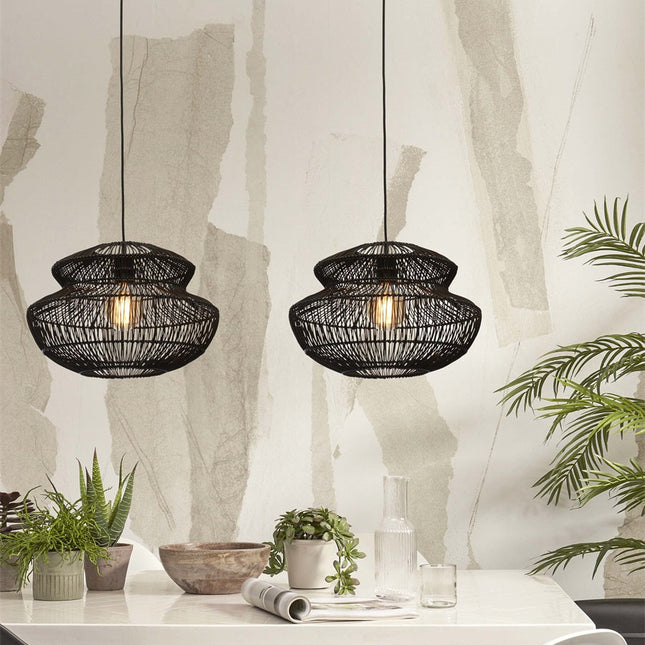 Two black woven rattan Zanzibar pendant lights above a table in a Japandi dining room